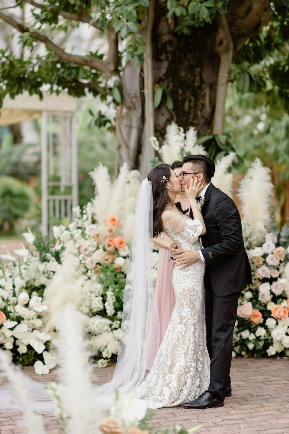 groom-in-tuxedo-with-bow-tie-kisses-bride-in-champagne-monique-lhuillier- wedding-dress | Wedding picture poses, Bride groom poses, Bride photo